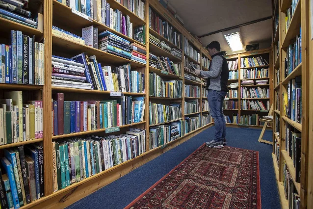 Tall wooden bookshelves filled with books inside The Open Book