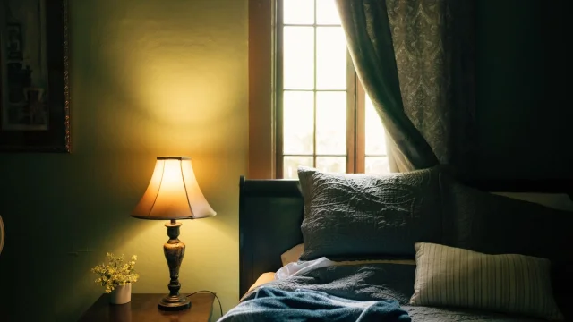 Dim bedroom with a lamp and curtains