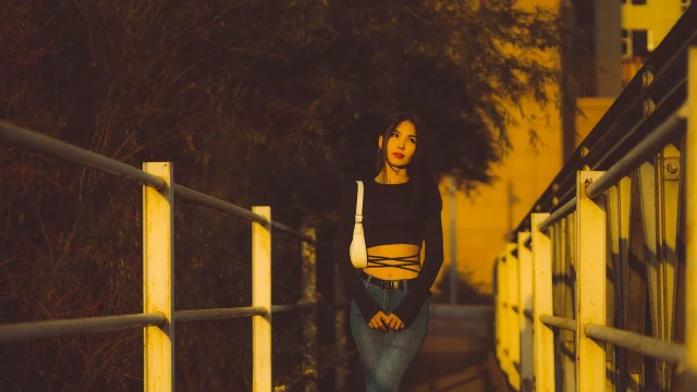 A black cropped top styled with denim in golden urban light