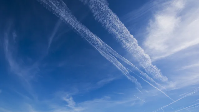 White contrails crossing a blue sky
