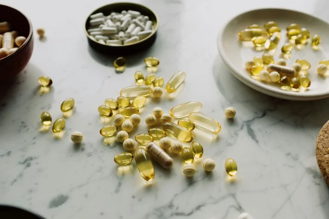Assorted pills and capsules on a marble surface