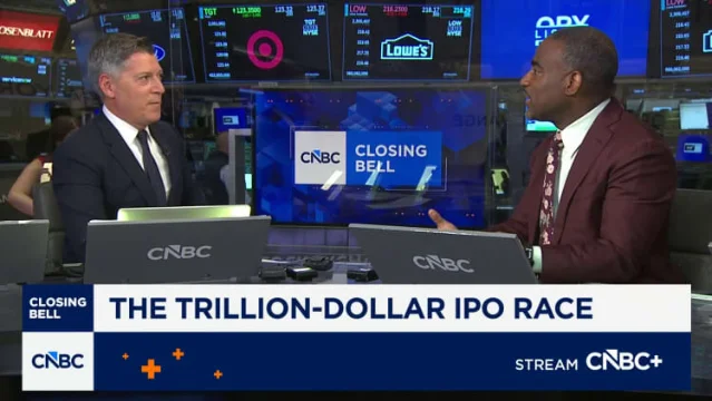CNBC studio screen showing "THE TRILLION-DOLLAR IPO RACE" headline