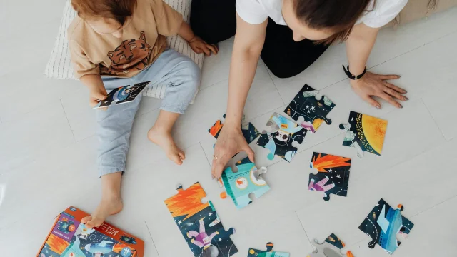 母子俯视拼图,孩子在地板上专注玩耍