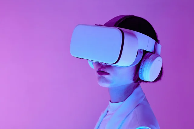 Woman wearing sleek AR/VR goggles in a modern studio, illustrating Apple's pivot from Vision Pro to lightweight smart glasses