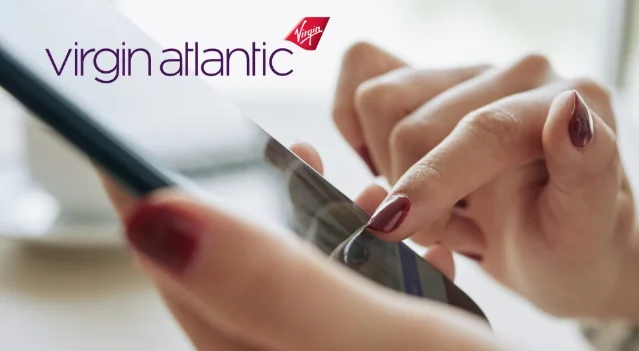 Virgin Atlantic brand logo over a person using a smartphone