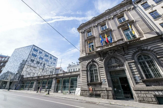 Brussels street with a historic stone facade and a modern faceted building