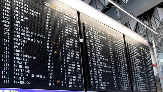Digital departure scoreboard showing rows of updating flight data — the AI League's live-updating stats panel in spirit
