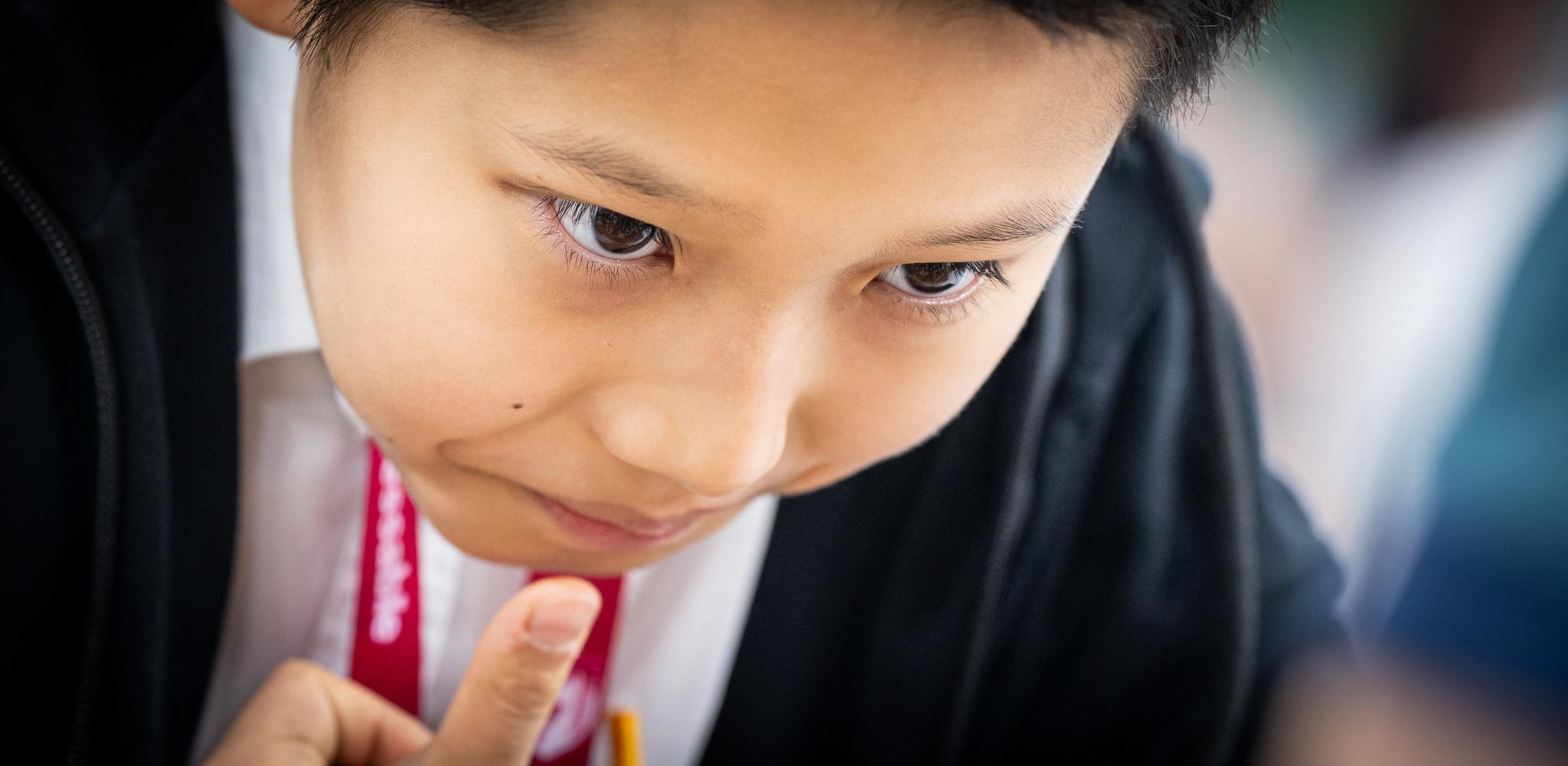Close portrait of Roman Shogdzhiev looking down at the board