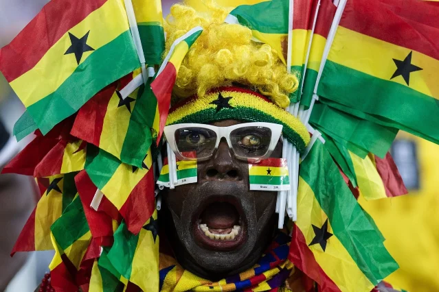 A Ghana supporter covered in flags