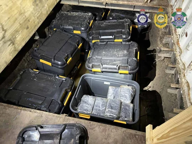 Inside one of the Londonderry shipping containers: a false floor panel lifted to reveal the cavity below, with sealed plastic drums packed tightly inside the hidden space