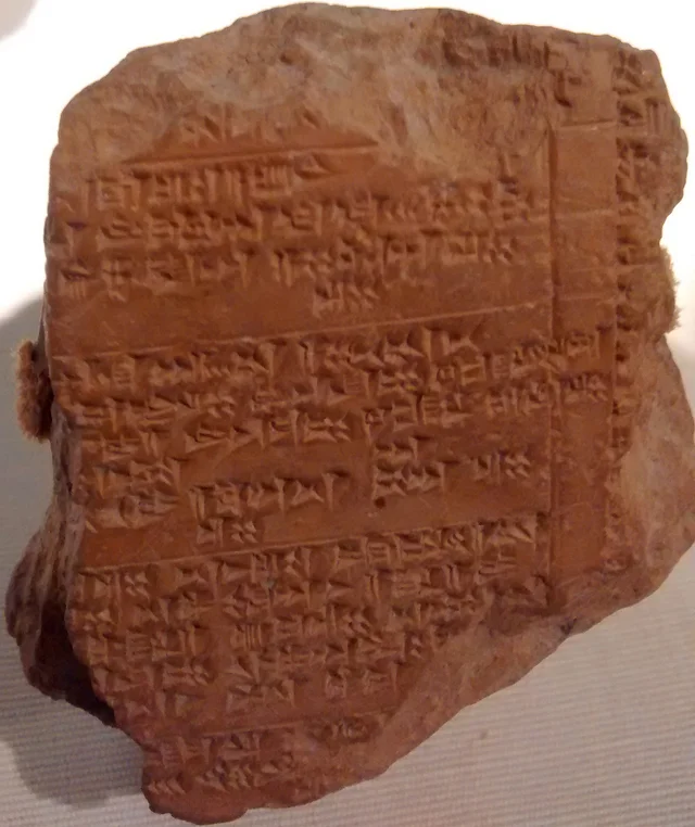A baked clay tablet covered in dense wedge-shaped cuneiform signs