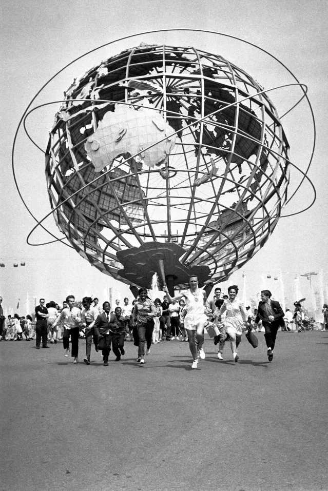 Buddy Edelen leads a crowd of children on a jog past the Unisphere at the 1964 New York World's Fair, May 22, 1964 — days before the Olympic Trials