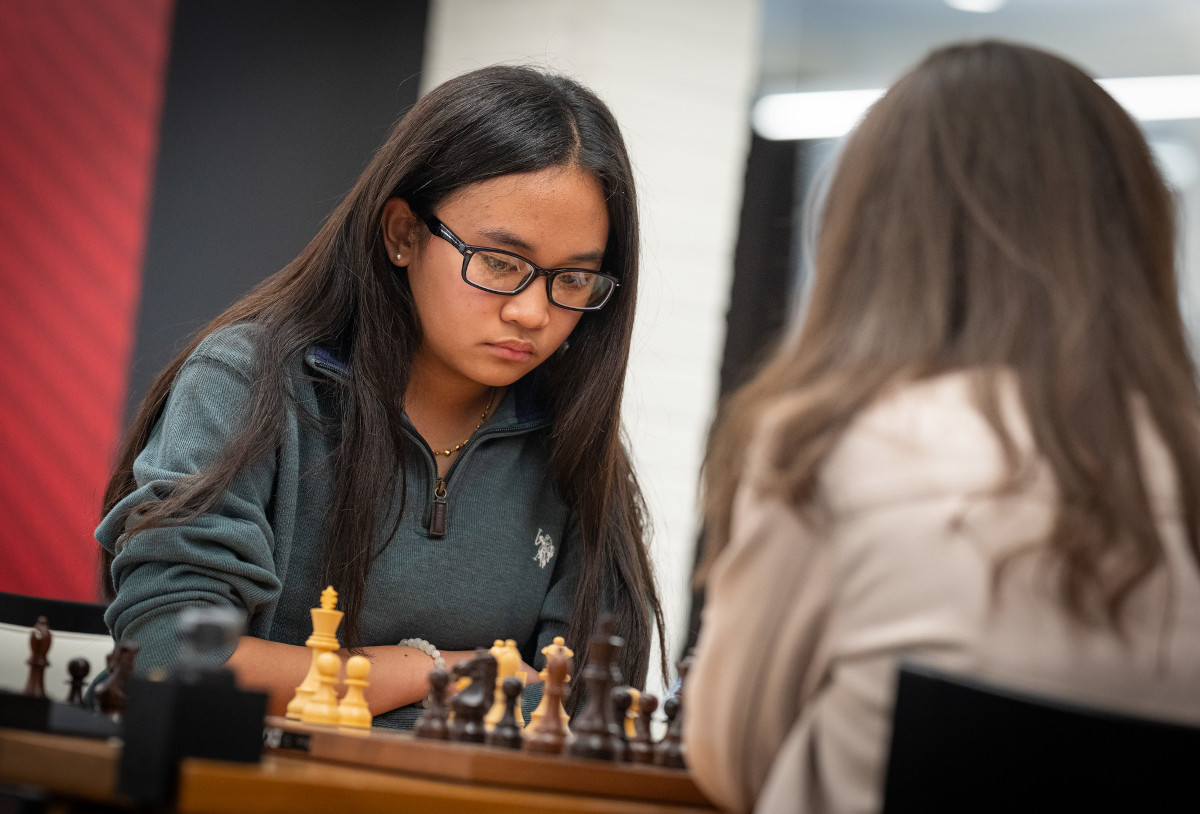 Megan Paragua at the board in round five, her opponent's back to the camera in the foreground