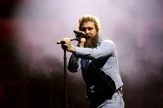 Post Malone performing under stage smoke and lights