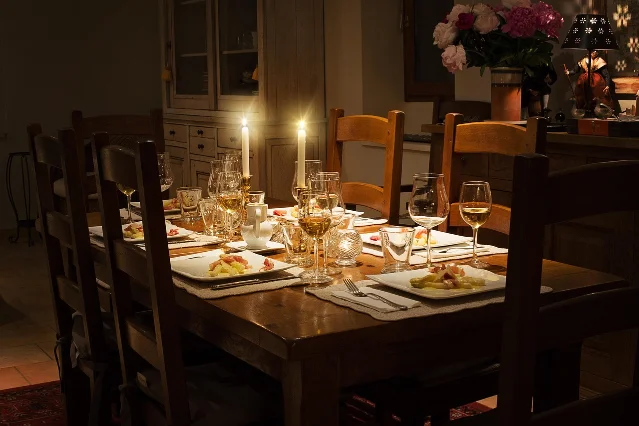 A dining table laid with plates, glasses and candles at home