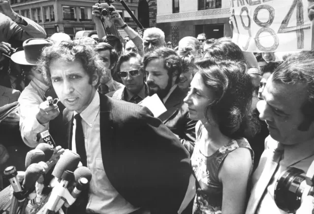 Daniel Ellsberg at federal courthouse in 1971, surrounded by reporters, wife at his side