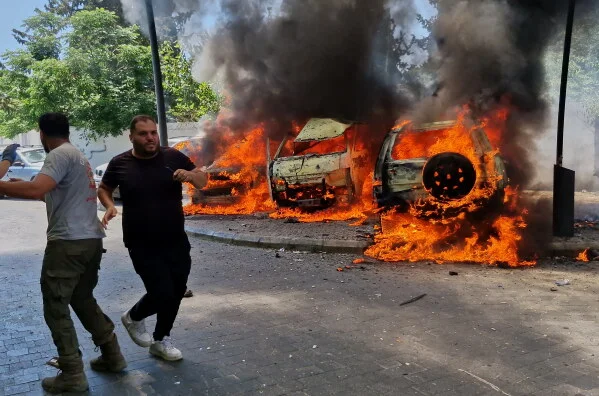 A man runs past burning cars following an Israeli airstrike in the southern port city of Sidon, Lebanon, Wednesday, June 10, 2026.
