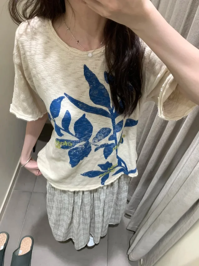米白上衣上的蓝色叶片印花与灰格半裙