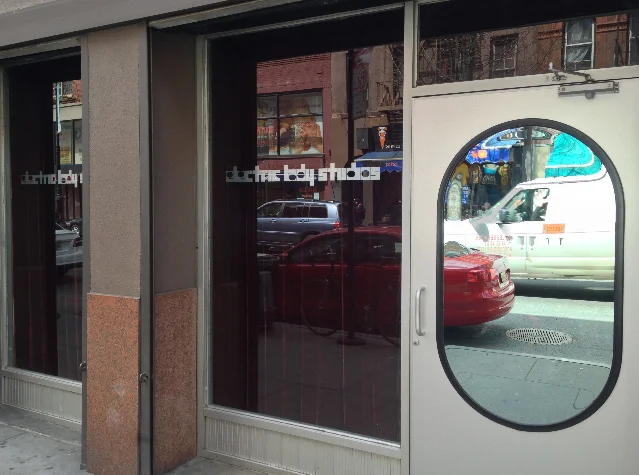 The glazed street entrance of a building in New York, with the words electric lady studios lettered on the glass