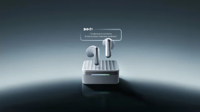 Silver Plaud One earbuds hovering above a ridged charging case on a reflective dark surface