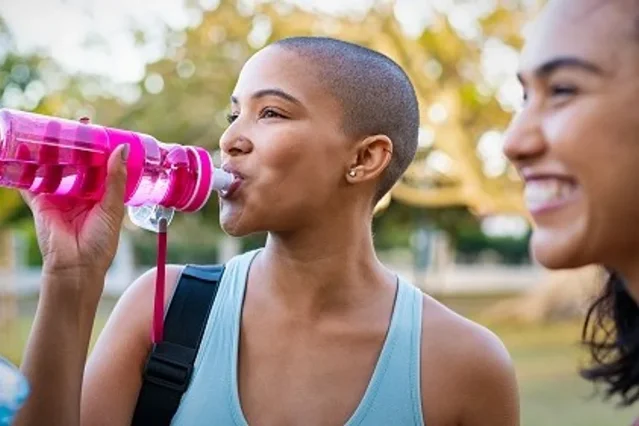Person drinking water from a reusable bottle