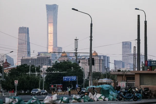 2026 年 5 月 11 日,北京街头,一名交警在疏导交通,背景是北京 CBD 的天际线