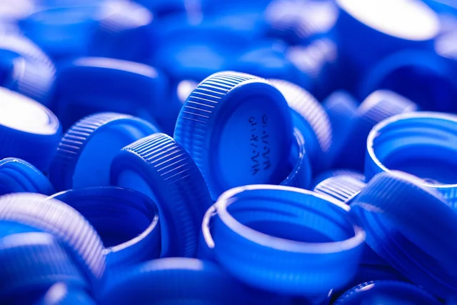 A heap of loose blue plastic bottle caps