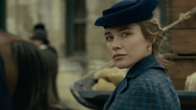 Florence Pugh in a blue hat and plaid coat turning to look over her shoulder in East of Eden