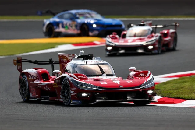 The red No. 8 Toyota Gazoo Racing hypercar leading another prototype through a corner at Fuji