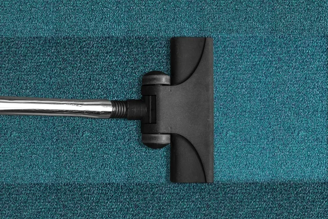 A vacuum head moving across carpet