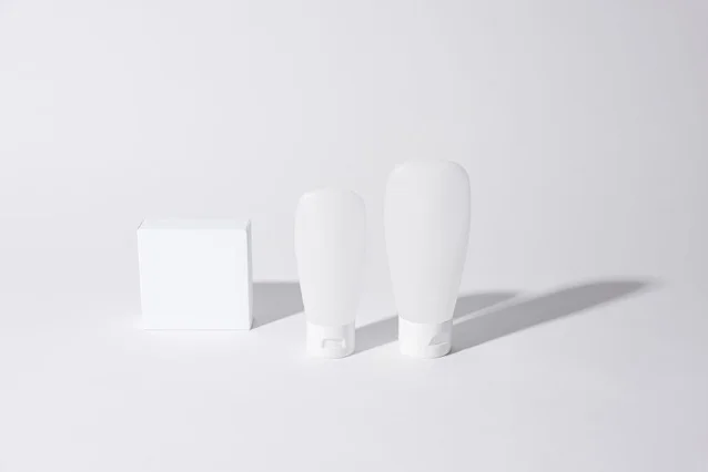 Minimalist studio product shot — cosmetic containers on white background with clean shadows, representing the commercial clarity that product photography negatives are designed to protect