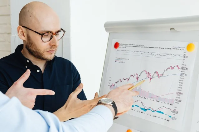 Two financial professionals debate the SpaceX valuation over charts at a meeting table