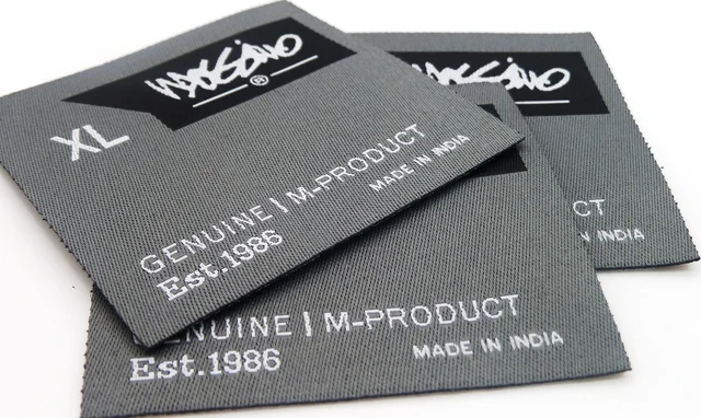 Woven clothing labels showing size, brand mark and country of manufacture