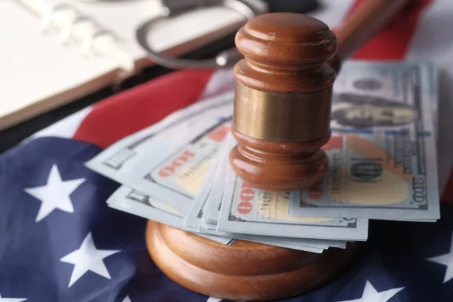 Gavel and dollar bills on a courtroom desk, representing financial stakes in broadcast license proceedings