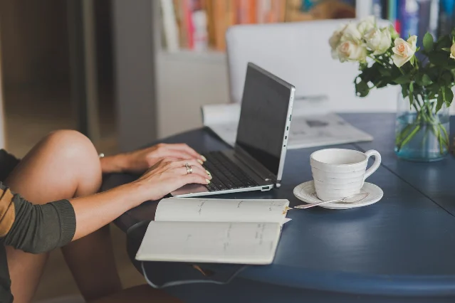Laptop with spreadsheet and business notes on a freelance work desk