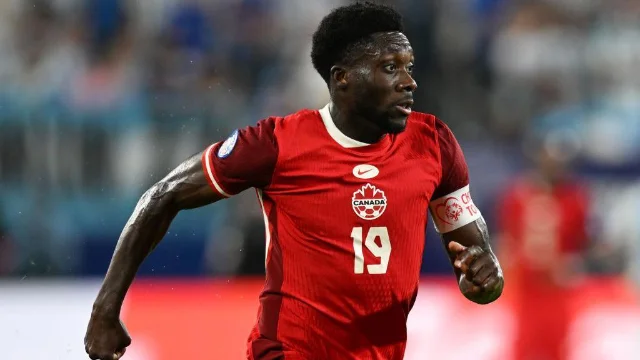 Alphonso Davies running in Canada's red kit