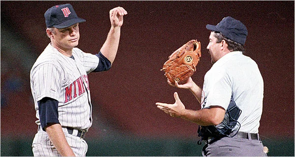 Joe Niekro hands over his glove during the mound inspection while catcher Sal Butera watches.
