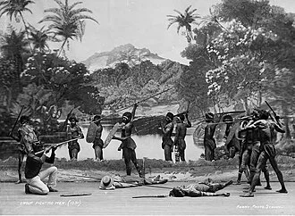 A staged frontier scene from the Wild Australia Show, with performers arranged around fallen figures