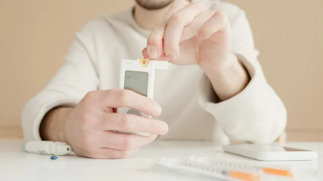 Person checking blood glucose with a glucometer, illustrating the metabolic link between sleep apnea and glycemic control