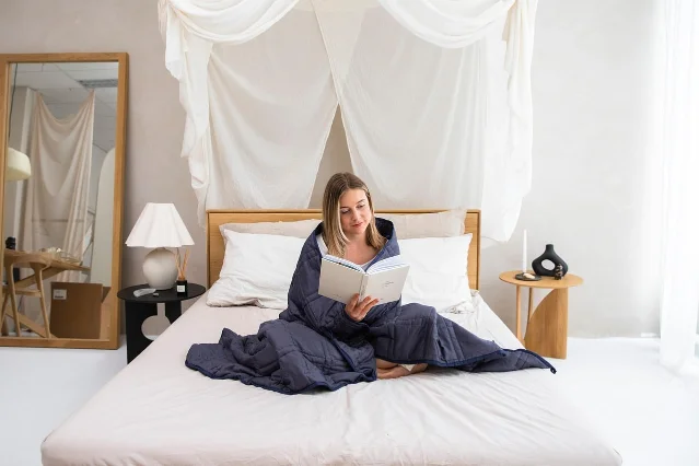 Woman reading on a bed as part of a quiet wind-down routine