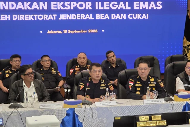 Indonesian customs officials seated at a press conference beneath a banner reading TINDAKAN EKSPOR ILEGAL EMAS