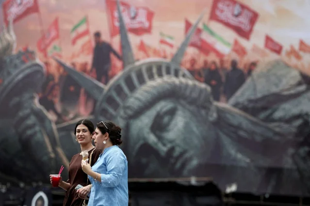People walk past an anti-U.S. billboard in Tehran