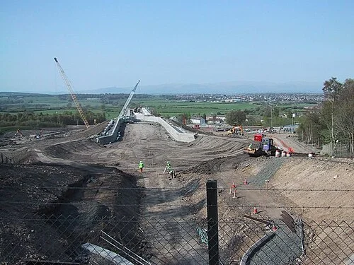 The Falkirk Wheel under construction, showing the basin excavation and the rising aqueduct approach