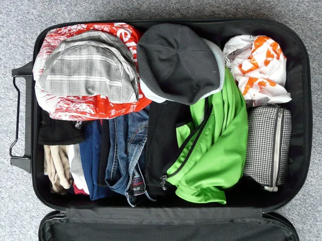 Open suitcase packed with clothes