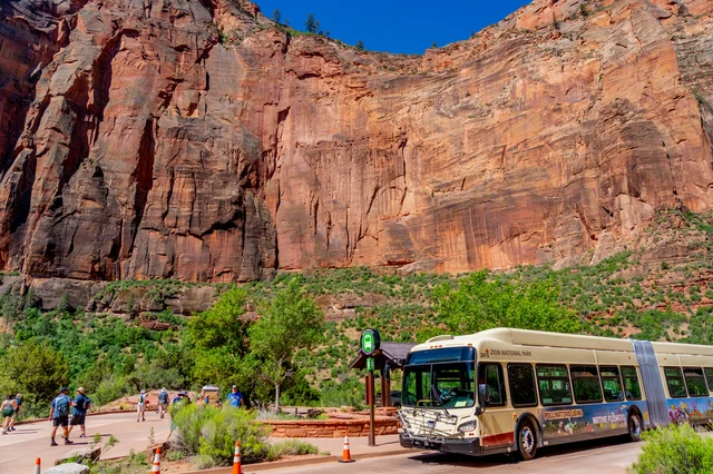 Zion Canyon electric shuttle stopped at Big Bend, with red canyon walls in the background