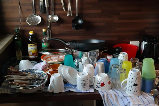 Dishes waiting beside a kitchen sink