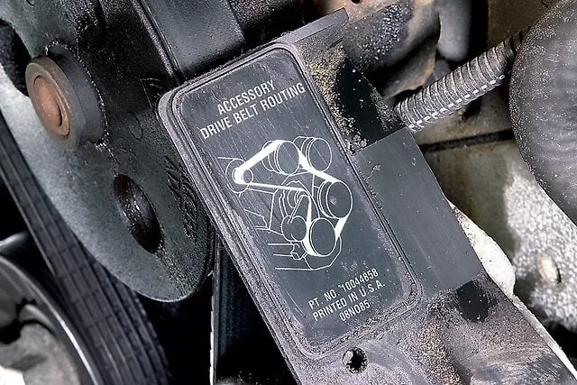 A belt-routing diagram mounted beside an engine pulley system.