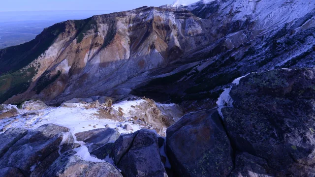 Volcanic ridgeline and rocky terrain on the Hokkaido mountain range with snow-capped peaks and sweeping views