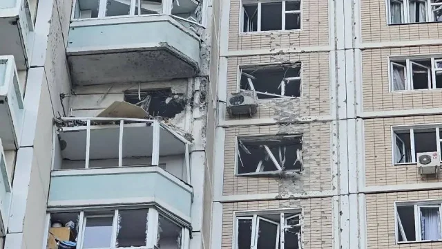 莫斯科地区高层公寓楼在无人机袭击中受损,两名男子在阳台检查损毁情况