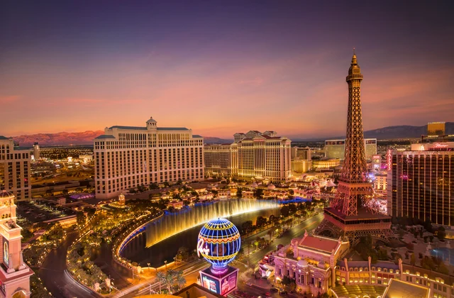 Aerial view of the Las Vegas Strip at sunset showing the Bellagio fountains, Paris Hotel Eiffel Tower replica, and surrounding casino hotels